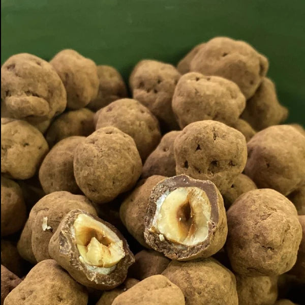 אגוזי לוז קלויים ומצופים בשוקולד עשיר ואבקת קקאו, מיוצרים בעבודת יד בשוקוליב.